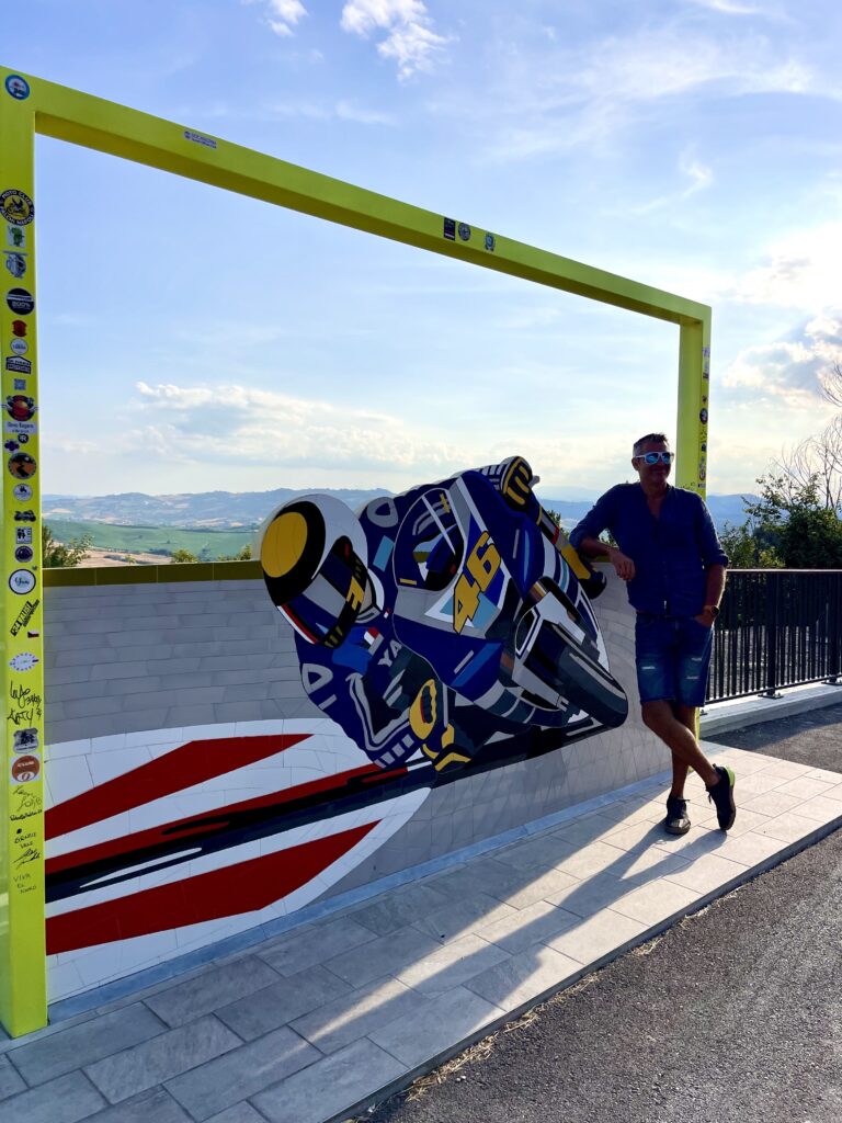 Bezoeker bij een racemotor van Valentino Rossi met uitzicht over de heuvels