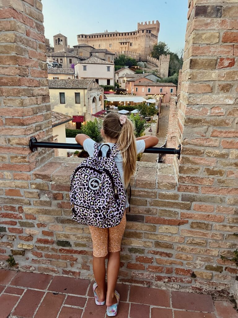 Kind kijkt vanaf de stadsmuren van Gradara uit over het landschap