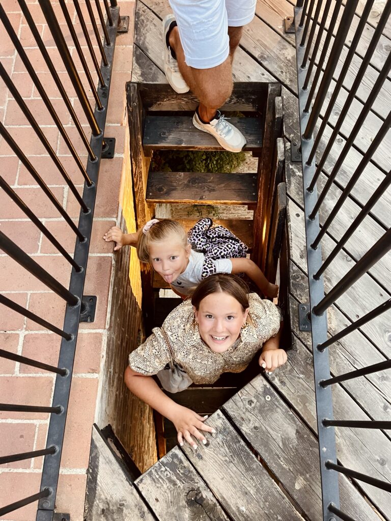 Kinderen beklimmen een smalle historische trap in Gradara