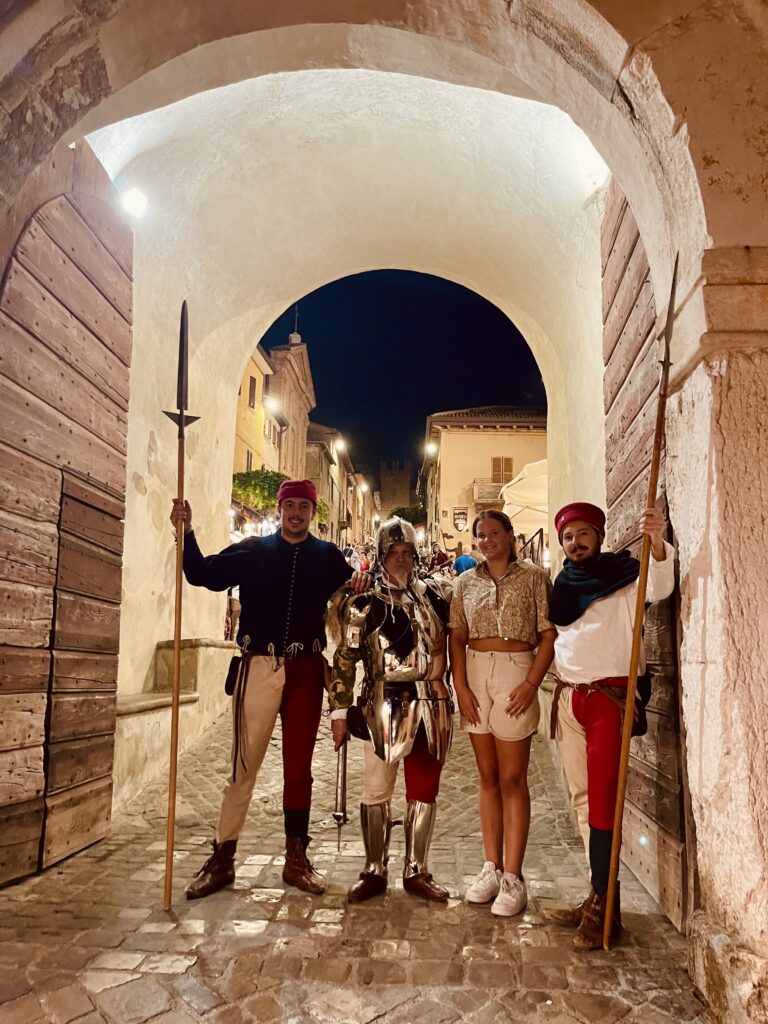 Gezin poseert onder een middeleeuwse stadspoort in Gradara